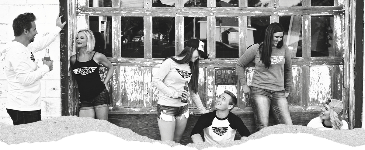 A group of friends in DogDayz Apparel tees outside a weathered storefront