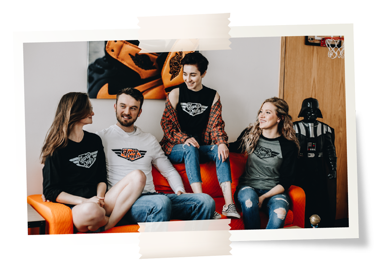 Five friends in DogDayz tees on a couch in a games room